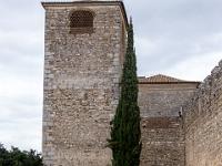 Schlanke Zypresse vor großem eckigem Wehrturm in Évora